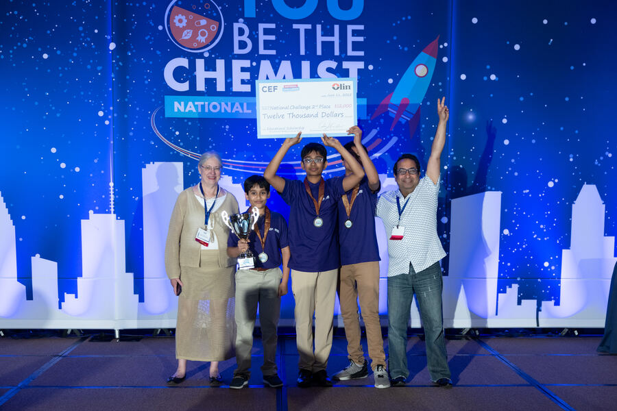 C0deEX team and coaches celebrating on stage at the National Challenge