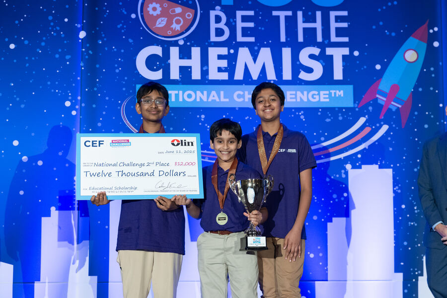 C0deEX team holding the First Runner-Up trophy on stage at the You Be The Chemist National Challenge